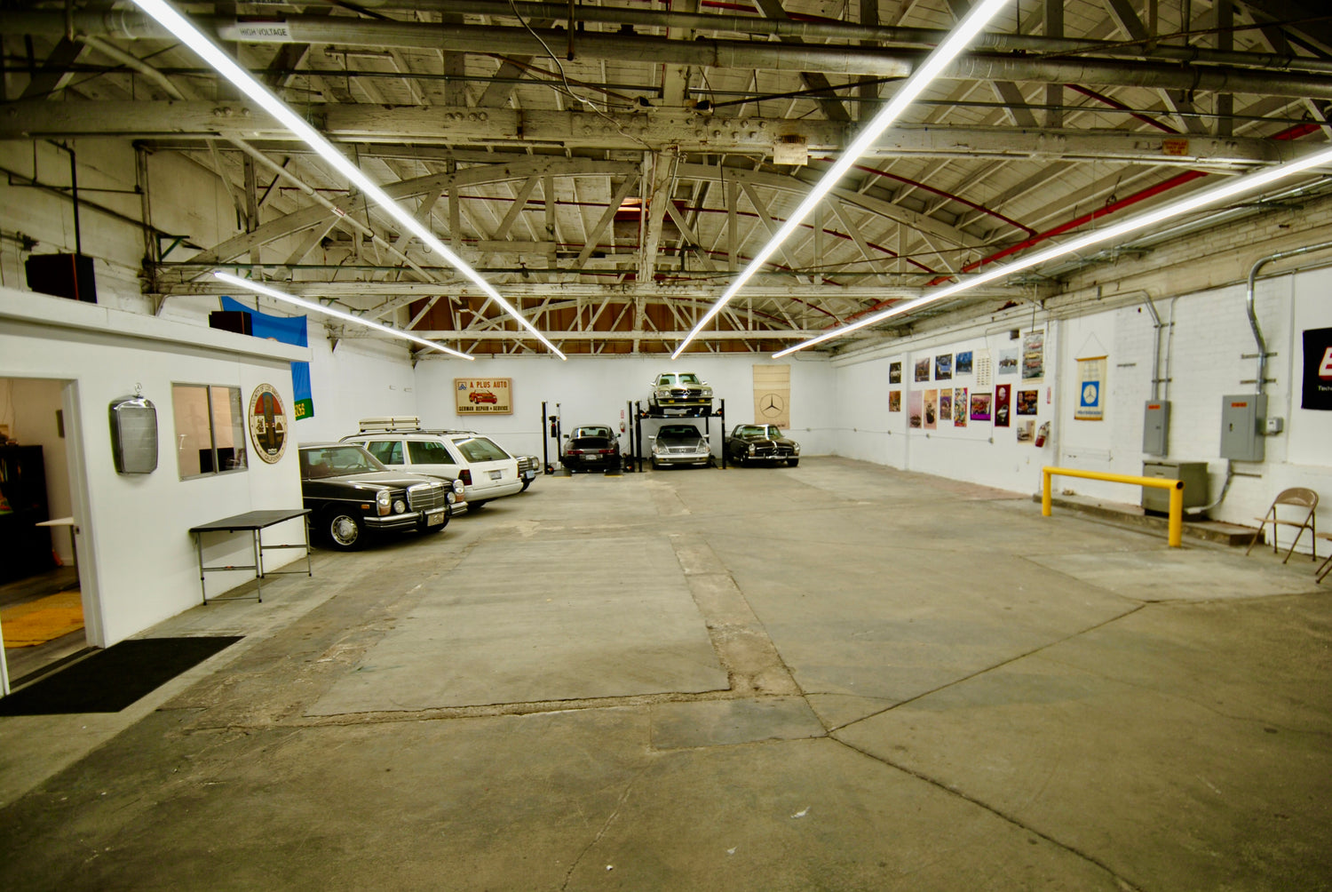 Large warehouse or industrial building with cars and equipment inside.